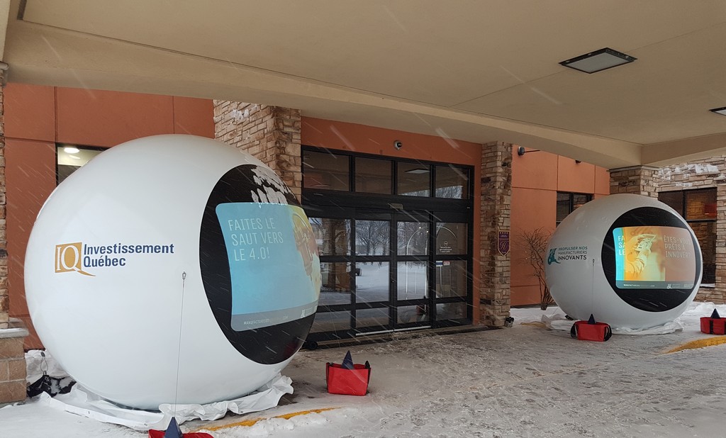 deux ballons munis d'écrans de rétroprojection devant une porte d'entrée d'un hôtel